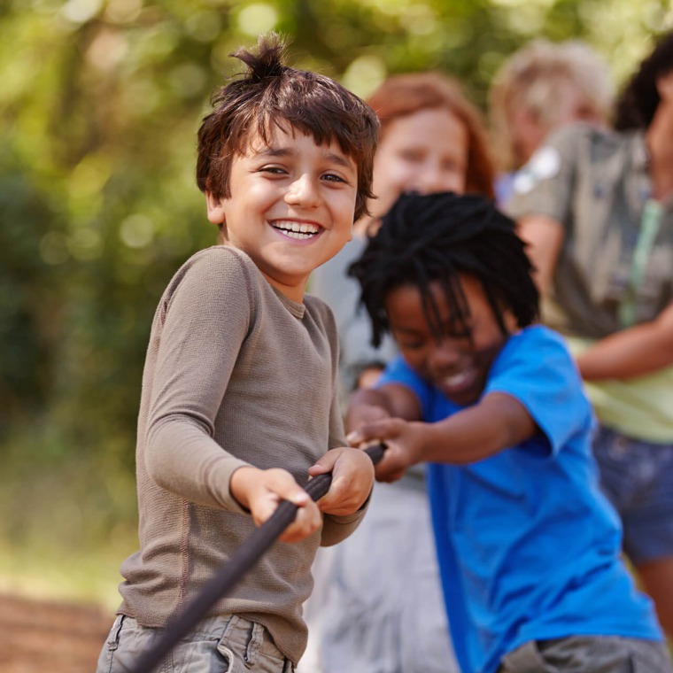 Children at a birthday party, laughing and eating cake.